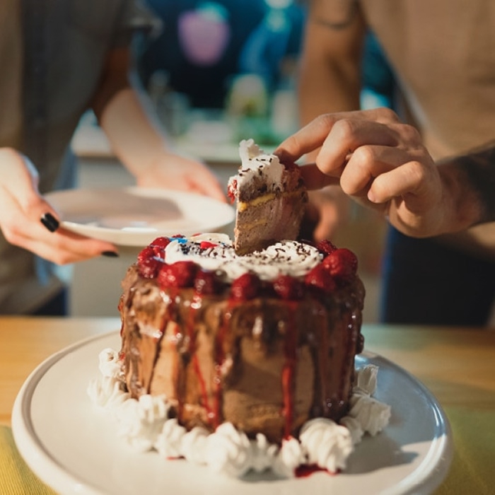 A person takes a piece of cake